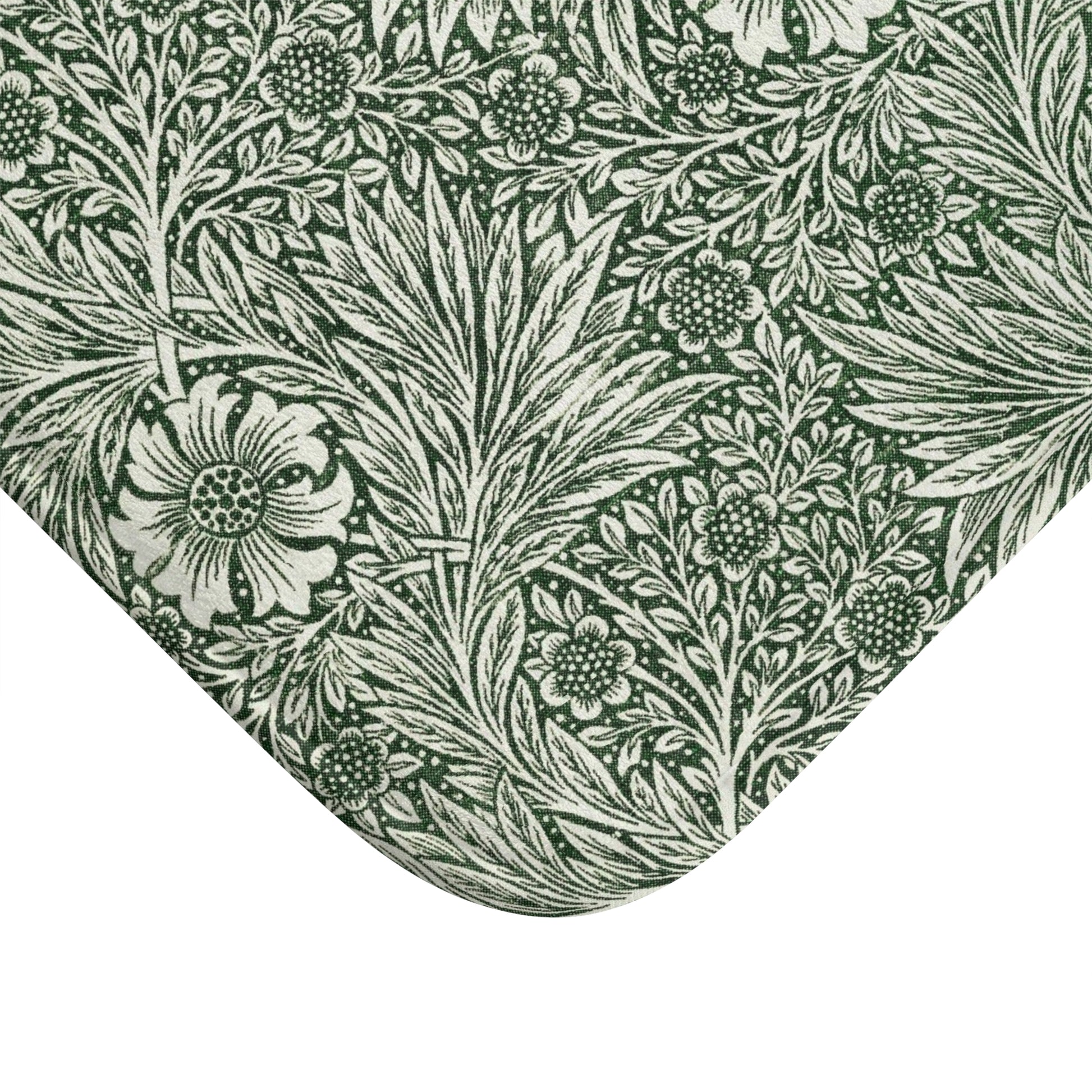 A rectangular microfibre bath mat with an all-over print of green and white floral patterns inspired by William Morris.