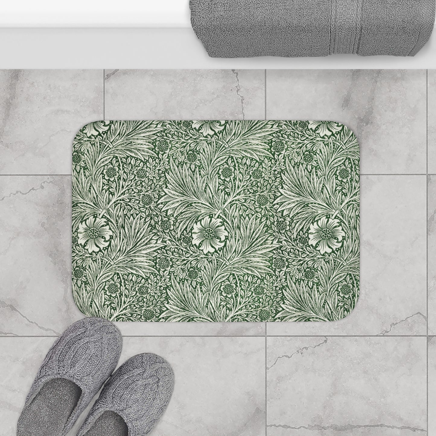 A rectangular microfibre bath mat with an all-over print of green and white floral patterns inspired by William Morris.