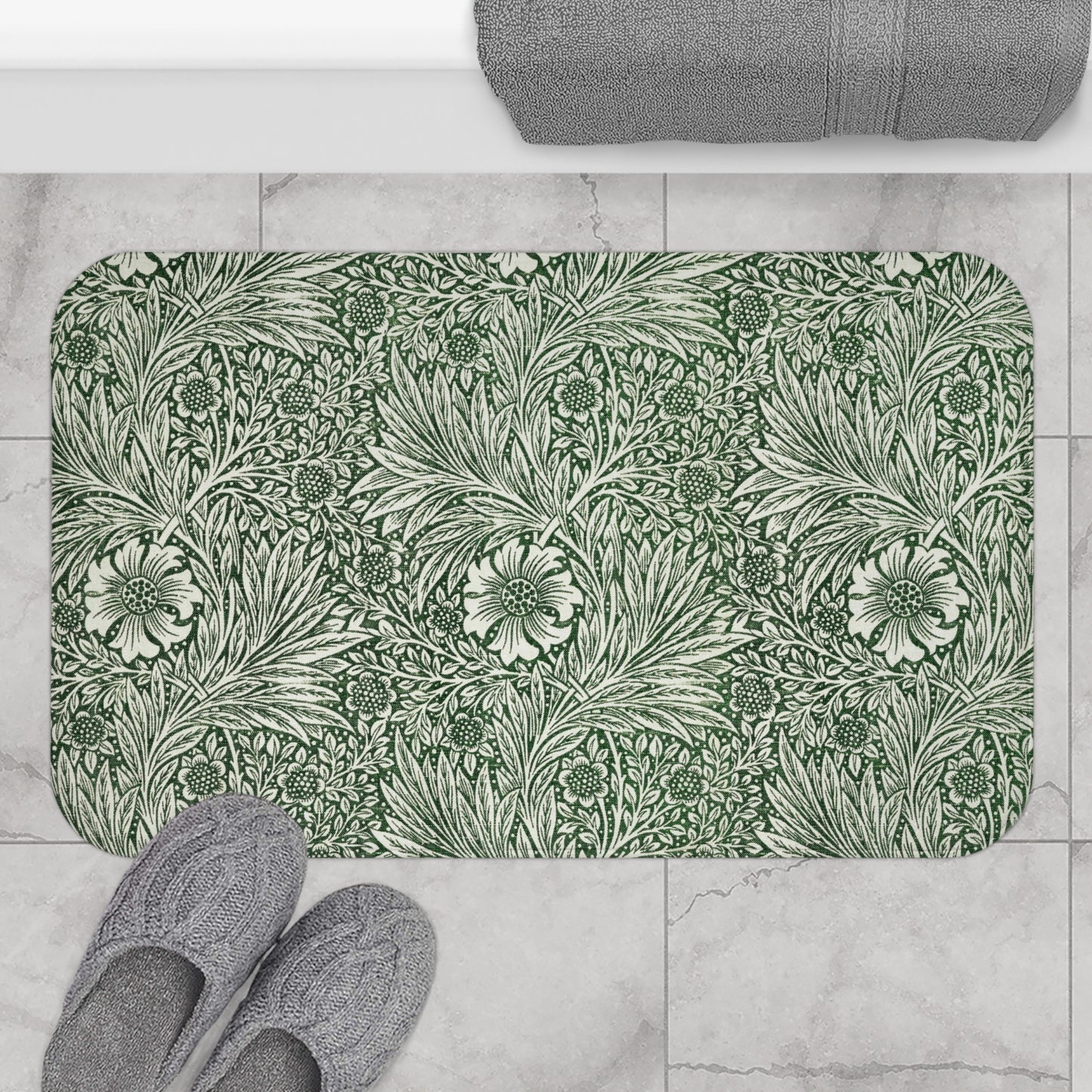 A rectangular microfibre bath mat with an all-over print of green and white floral patterns inspired by William Morris.