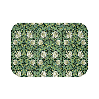 A rectangular mat with rounded corners featuring a repeating William Morris-style floral pattern in green, cream, and yellow on a white background.