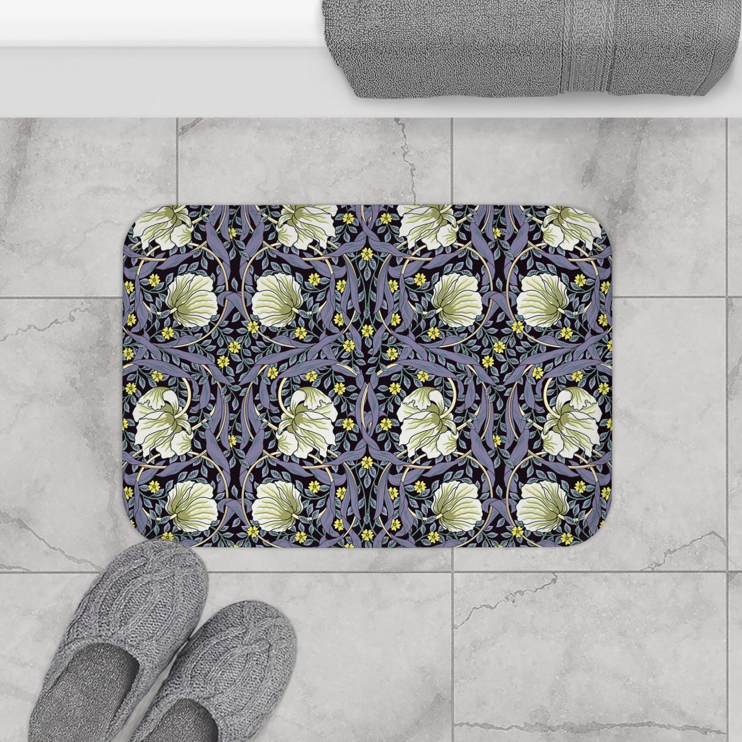 A rectangular microfibre bath mat with a floral pattern in shades of purple and green, inspired by William Morris' design.