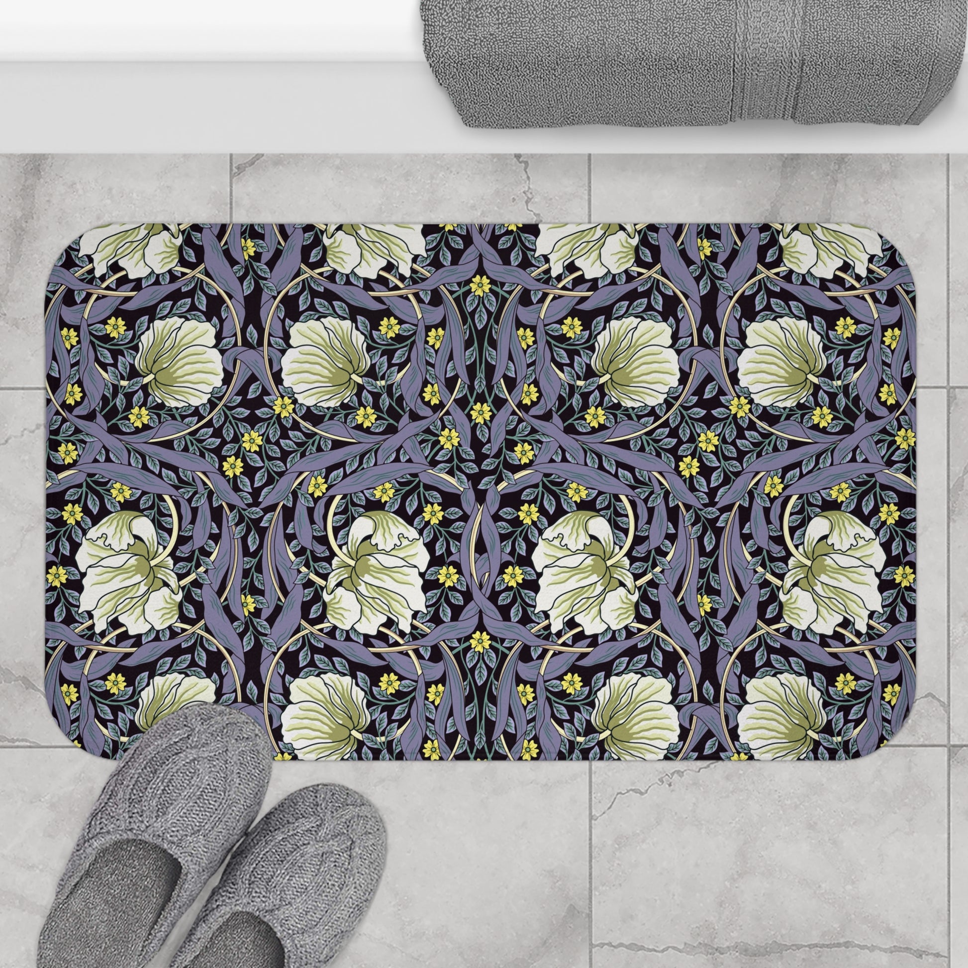 A rectangular microfibre bath mat with a floral pattern in shades of purple and green, inspired by William Morris' design.