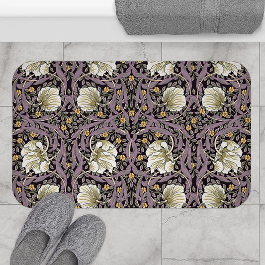 Decorative doormat with floral pattern on a tiled floor, accompanied by gray slippers.