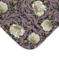 Floral patterned fabric with white flowers and purple leaves on a dark background