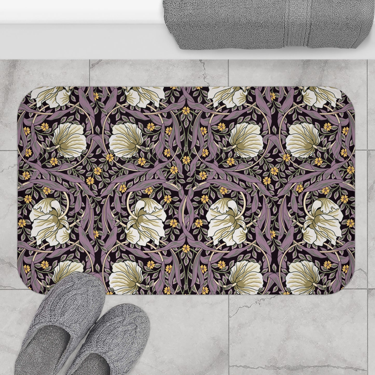 A rectangular microfibre bath mat with a floral pattern inspired by William Morris, predominantly in pink, purple and gold colours.