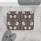 Decorative bathmat with floral pattern on a tiled floor, accompanied by slippers and a towel.