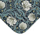 A rectangular microfibre bath mat with a floral pattern in shades of blue and white, inspired by William Morris' design.