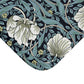A rectangular microfibre bath mat with a floral pattern in shades of blue and white, inspired by William Morris' design.