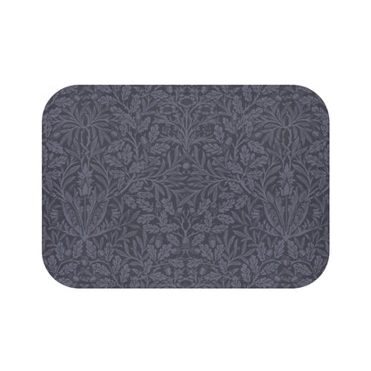 A rectangular microfibre bath mat with an all-over print of acorns and oak leaves in a smoky blue colour.
