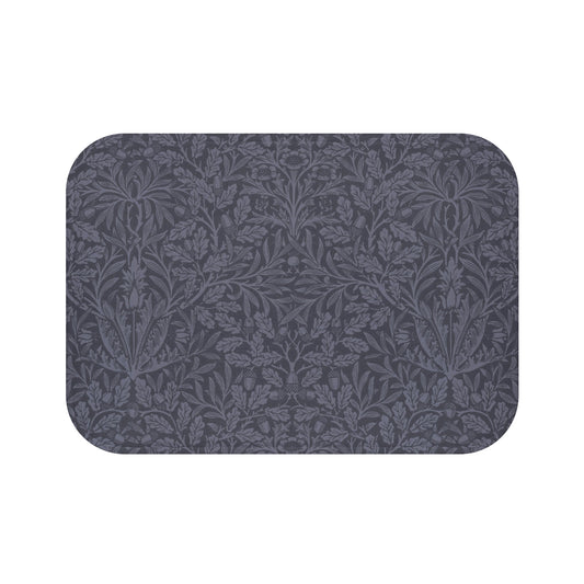 A rectangular microfibre bath mat with an all-over print of acorns and oak leaves in a smoky blue colour.