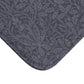 A rectangular microfibre bath mat with an all-over print of acorns and oak leaves in a smoky blue colour.