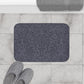 A rectangular microfibre bath mat with an all-over print of acorns and oak leaves in a smoky blue colour.