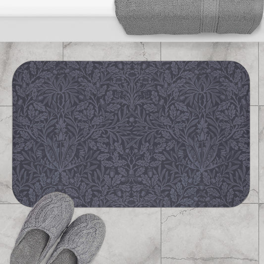 A rectangular microfibre bath mat with an all-over print of acorns and oak leaves in a smoky blue colour.