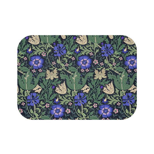 A rectangular microfibre bath mat with a floral pattern inspired by William Morris, predominantly blue and green in color.