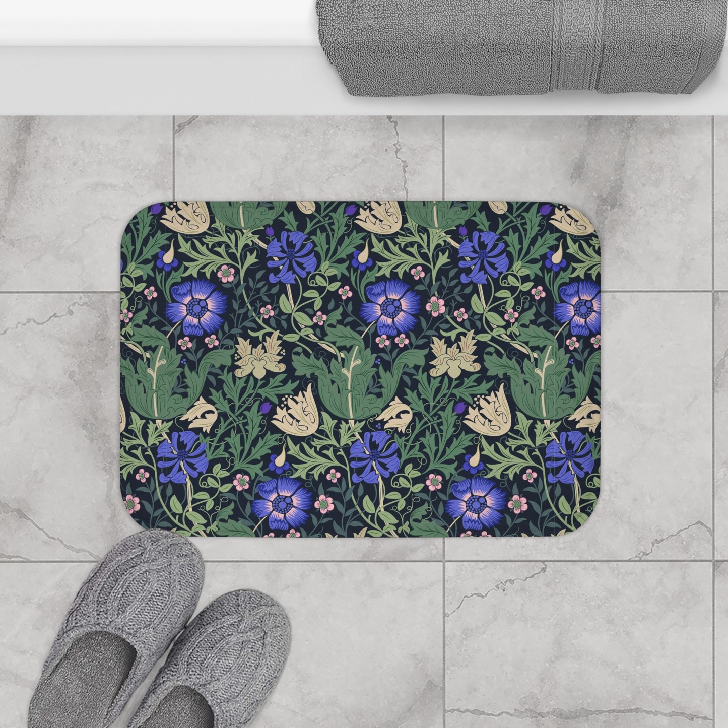 A rectangular microfibre bath mat with a floral pattern inspired by William Morris, predominantly blue and green in colour.