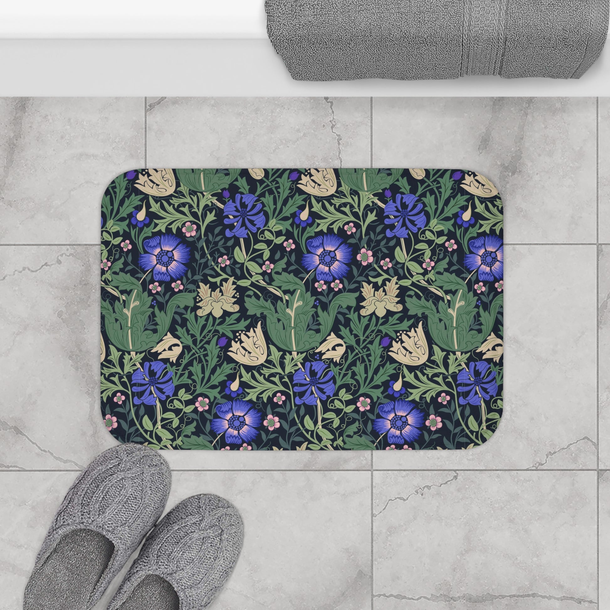 A rectangular microfibre bath mat with a floral pattern inspired by William Morris, predominantly blue and green in colour.