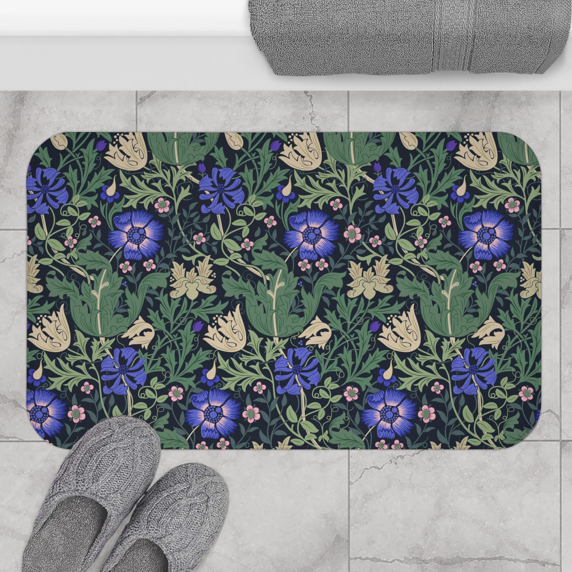 A rectangular microfibre bath mat with a floral pattern inspired by William Morris, predominantly blue and green in colour.
