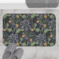 Microfibre bath mat with a floral pattern inspired by William Morris, predominantly yellow flowers with green leaves on a black background.