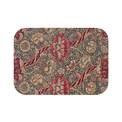 A rectangular microfibre bath mat with a floral pattern inspired by William Morris, predominantly red with a non-slip black border.