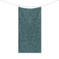 A rectangular bath towel hanging from a clothesline with two wooden clips, featuring an all-over botanical and floral pattern in muted teal and blue-green tones on a white background.