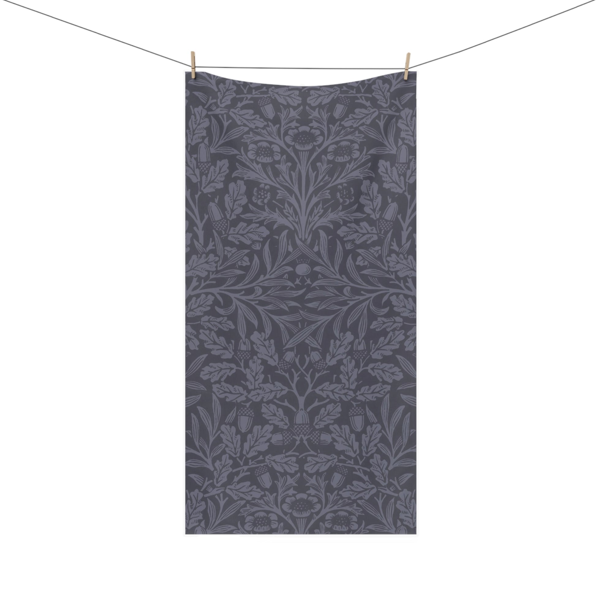 A rectangular fabric towel or scarf with a dark gray and slate blue botanical damask pattern, hanging from a clothesline with two wooden clips against a solid white background.