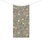 A rectangular bath towel from a clothesline with two wooden clips, featuring an all-over botanical and bird pattern on a dusty pink background with green leaves, brown branches, and small birds.