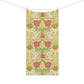 A rectangular bath towel with a symmetrical floral pattern, hanging from two wooden clothespins on a thin horizontal line against a solid white background.