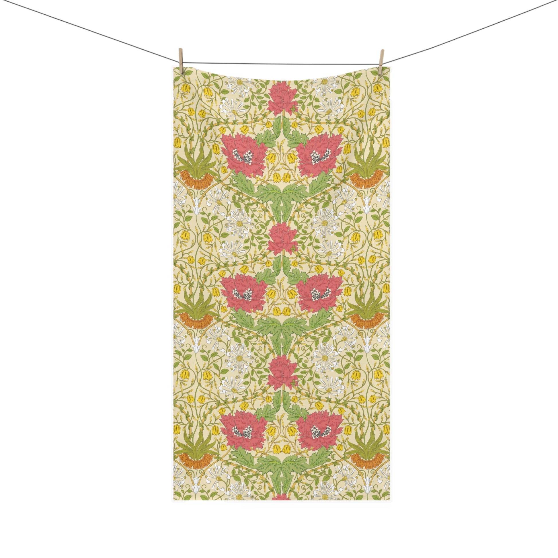 A rectangular bath towel with a symmetrical floral pattern, hanging from two wooden clothespins on a thin horizontal line against a solid white background.