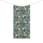 A rectangular bath towel, featuring a dense botanical pattern with blue flowers, green leaves, and yellow vines on a dark navy background. It is shown hanging from a clothesline with two wooden clips against a plain white background.