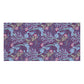 A rectangular bath towel featuring a dense botanical pattern with blue-gray leaves, pink flowers, and light green stems on a dark purple background, shown against a plain white backdrop.