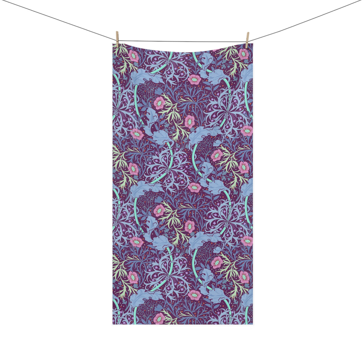 A rectangular bath towel with a dense floral and botanical pattern, hanging from a clothesline with two wooden clips against a plain white background.