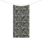 A rectangular fabric towel with a dense botanical pattern, hanging from a clothesline with two wooden clips against a plain white background.