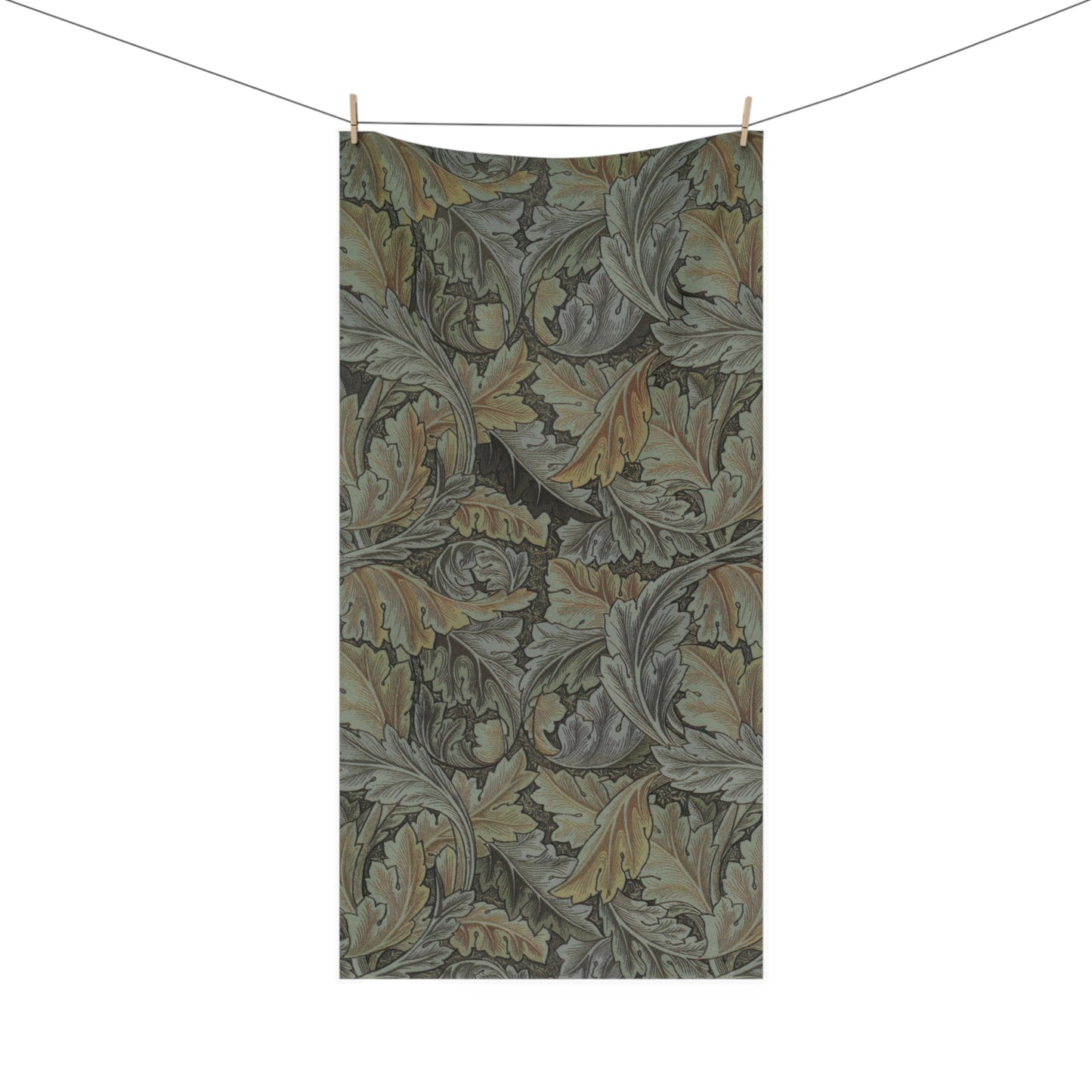 A rectangular fabric towel or blanket with an intricate vintage-style botanical pattern of oak leaves, hanging from a clothesline with two wooden clips against a solid white background.