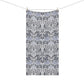 A rectangular towel with a classic William Morris-style floral damask pattern in gray, white, and muted blue-gray, hanging from a clothesline with two wooden clips against a plain white background.