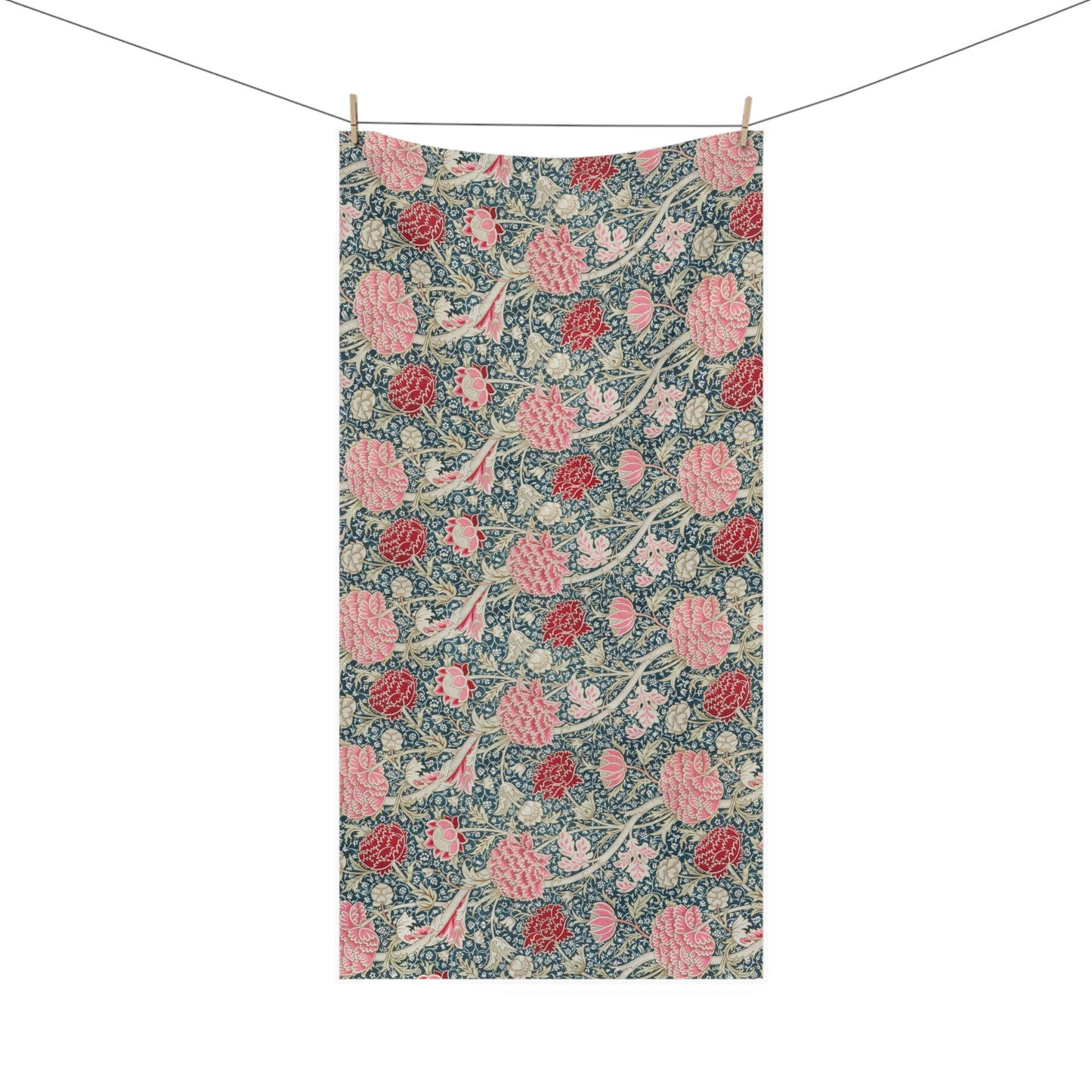 A rectangular fabric towel with a vintage floral pattern, hanging from two wooden clothespins on a string against a plain white background.