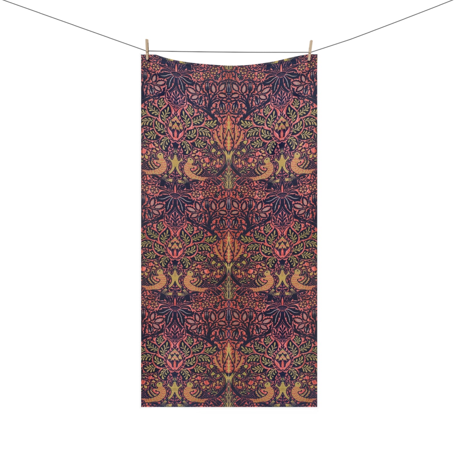 A rectangular textile with an intricate botanical and bird pattern in dark navy, pink, and olive green, hanging from a clothesline with two wooden clips against a plain white background.
