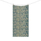 A rectangular textile hanging from a clothesline with two wooden clips, featuring an all-over dense floral and botanical pattern in muted teal, beige, and soft pink tones against a plain white background.