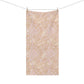 A rectangular fabric towel or scarf hanging from a clothesline with two wooden clips, featuring a repeating botanical pattern in soft blush pink and cream on a warm beige background.