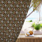 Decorative curtain with floral pattern in front of a beach view with coconuts on a table.