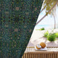 Decorative curtain with floral pattern next to a table with coconuts on a beach setting