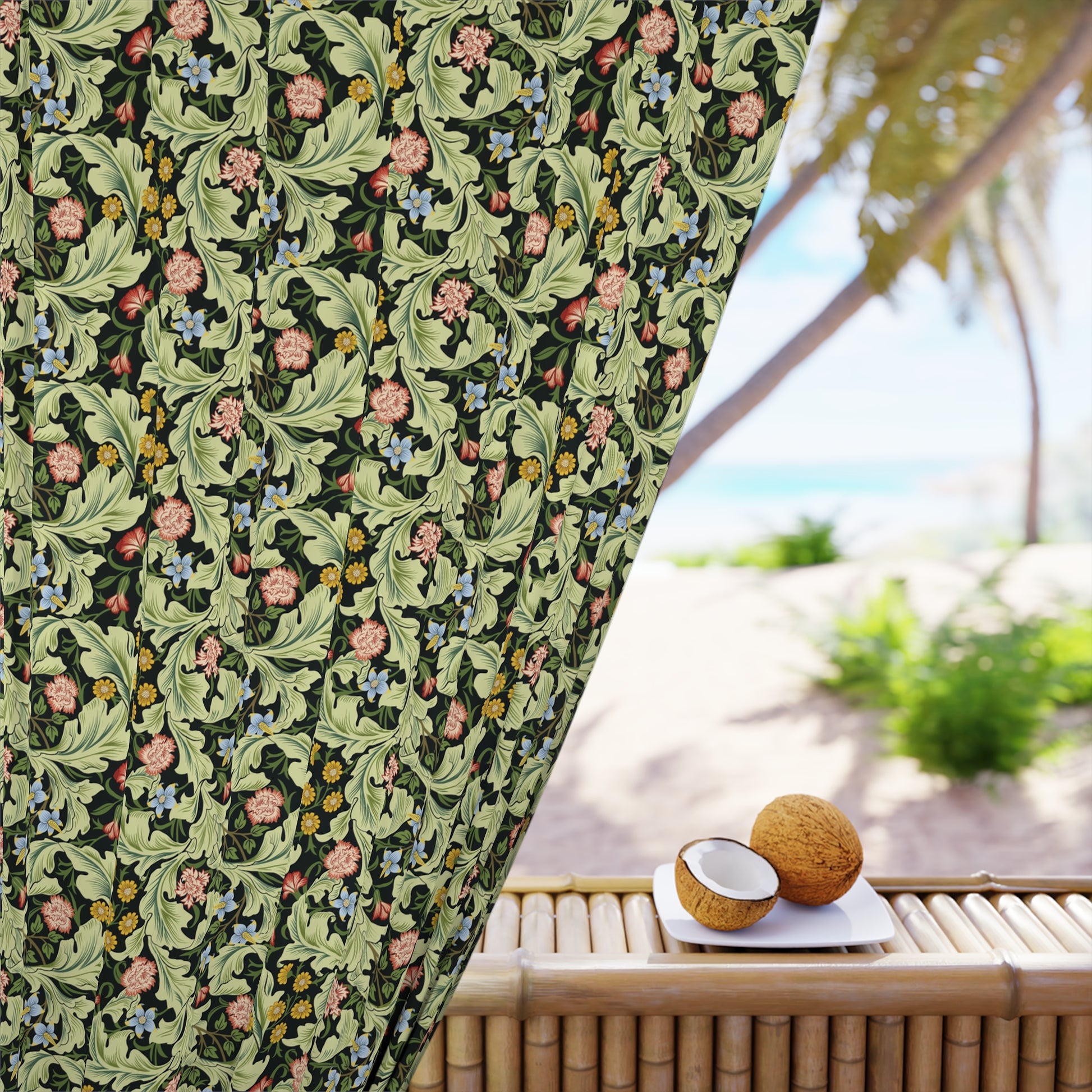 Decorative curtain with floral pattern next to a table with coconuts on a beach setting
