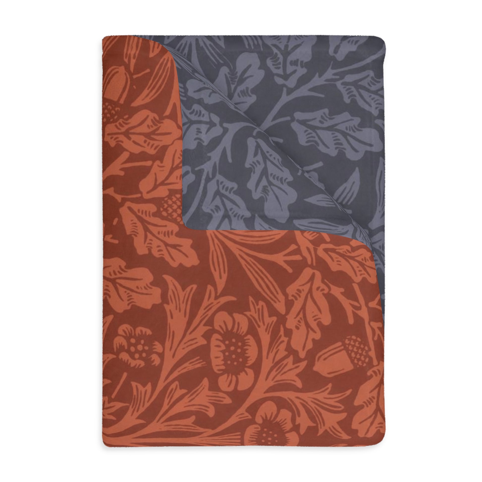 A rectangular blanket with a two-sided print featuring floral designs and a central panel with a darker, solid-colored section on one side.