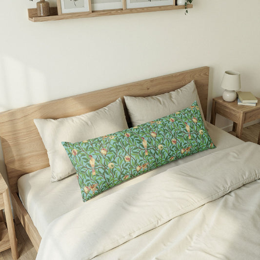 Bedroom with a wooden headboard and a long green floral pillow on a bed.