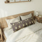 Bedroom with a wooden bed frame and floral-patterned pillow