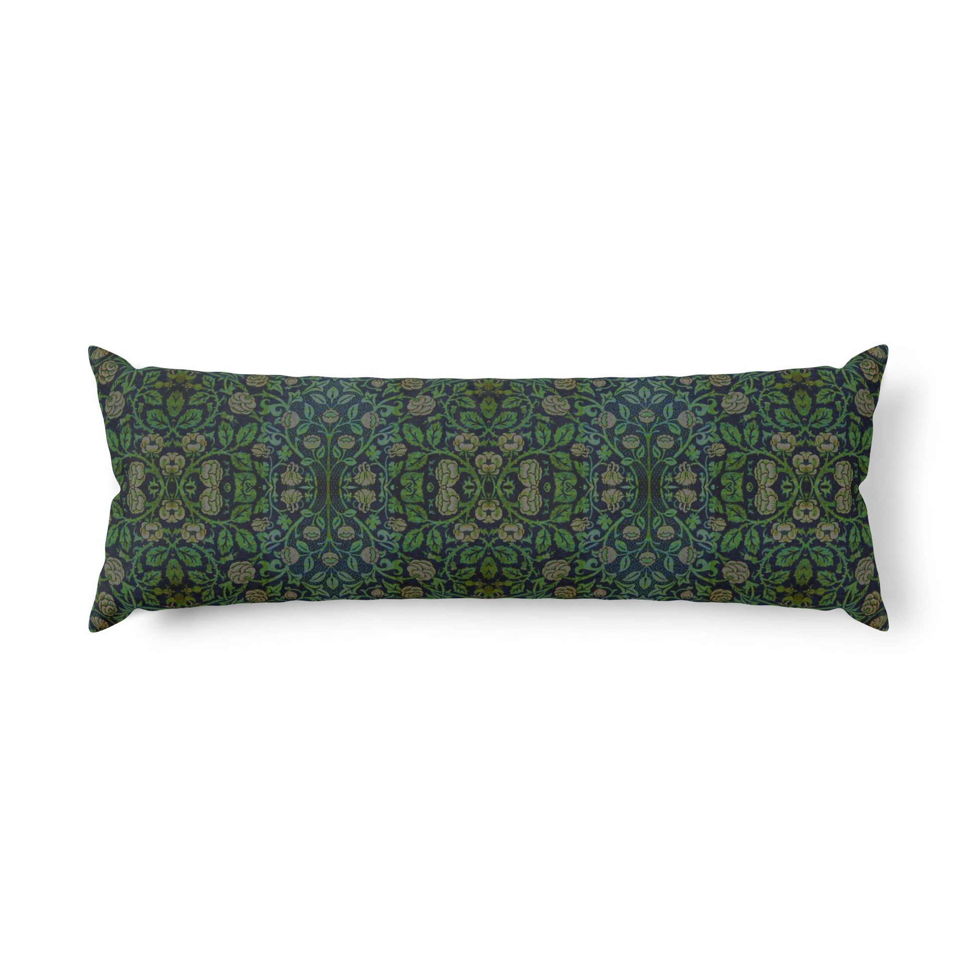 A long rectangular lumbar pillow with an intricate William Morris & Co green and brown paisley pattern rests on a bed with cream bedding and white pillows in a minimalist, warm-toned bedroom.
