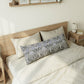 Bedroom with a wooden bed frame and decorative pillows on a bed.