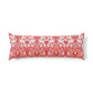 Bed with wooden headboard and decorative pillows, including a red floral pillow in a William Morris pattern called Brer Rabbit.