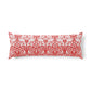 Bed with wooden headboard and decorative pillows, including a red floral pillow in a William Morris pattern called Brer Rabbit.