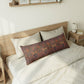 Bedroom with a wooden bed frame, white bedding, and a camouflage-patterned pillow.
