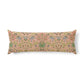 A long rectangular lumbar pillow featuring a dense botanical and floral pattern in muted green, blue, and gold on a dusty pink background, shown against a plain white studio background.